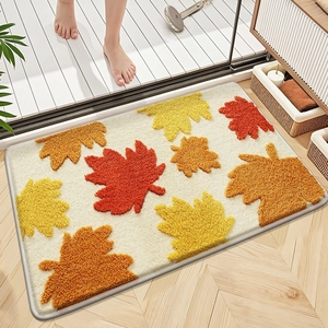 Detail of plush microfiber bath mat with orange autumn leaves pattern in home setting
