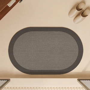 Detail of oval absorbent bath mat showing bicolored woven linen texture and non-slip surface