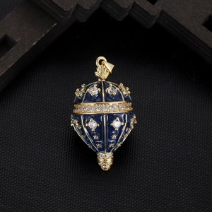 Close-up of blue enamel egg pendant with gold trim and inlaid sparkling zircons