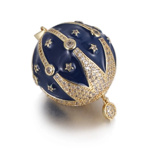 Macro shot of blue enamel hot air balloon pendant with gold stars and crystal details