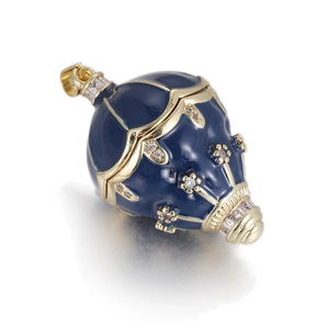 Macro detail of egg-shaped pendant with dark blue enamel and gold-plated metal flower design