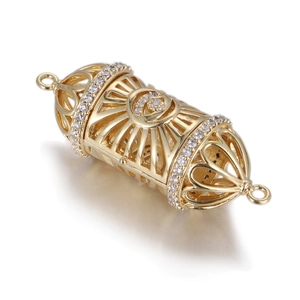 Close-up of golden hollow cylindrical pendant with heart patterns and small diamonds