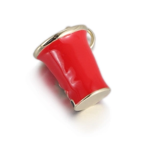 Detailed macro shot of a cute red enamel cup pendant charm with gold plated copper edges
