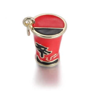 Detail of a red enamel cup pendant with golden metal trim and sleek black tribal patterns