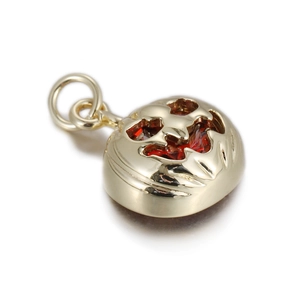 Détail macro du pendentif citrouille avec motif évidé doré et cristal facetté rouge