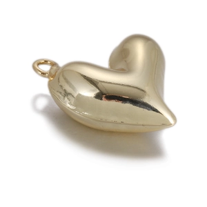 Gros plan du pendentif cœur doré avec surface polie et boucle de connexion en métal