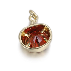 Détail d'un pendentif en pierre rouge ronde avec socle en cuivre doré et serti à griffes robuste