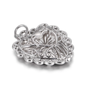 Détail macro du pendentif cœur en argent avec dentelle découpée complexe et courbes fines