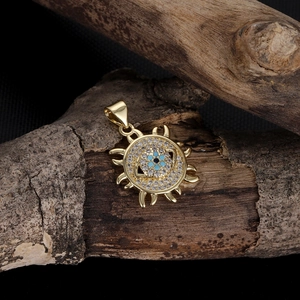 Macro shot of gold 14k Evil Eye pendant with zircon micro-pave on dark wood bark