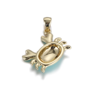 Detailed macro view of a polished gold-plated copper crab pendant for DIY jewelry