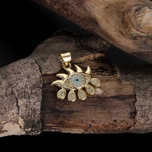 Detailed close-up of golden evil eye pendant with blue zircon and teardrop charms
