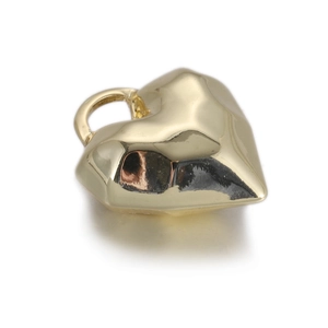 Détail d'un pendentif coeur doré avec un design géométrique irrégulier et facetté