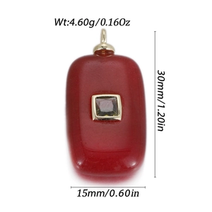 Macro view of red rectangular gemstone pendant with gold inlay and size measurements