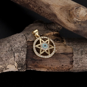 Macro detail of 14k gold-plated hexagram pendant with blue evil eye and zircon inlay
