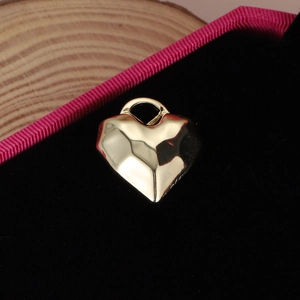 Pendentif cœur doré facetté avec surface géométrique sur boîte à bijoux en velours