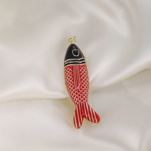 Macro shot of koi fish pendant with black and red enamel on soft silk fabric
