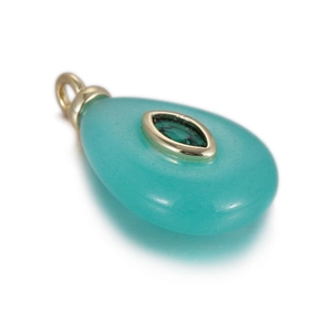 Macro detail of teardrop natural stone pendant with marquise green zircon in gold plating