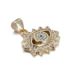Close-up of a sun-shaped evil eye pendant in gold finish with white zircon inlay