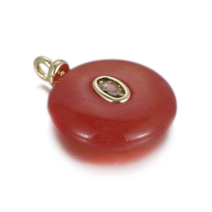 Detailed view of carnelian stone pendant with inlaid green zircon and gold plating