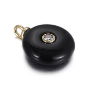 Detailed view of round black stone pendant with center faceted zircon in gold setting