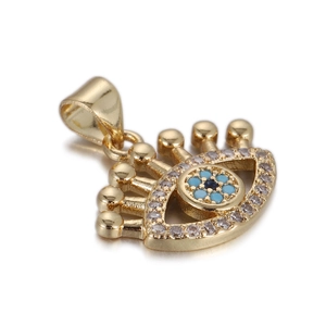 Detailed close-up of golden evil eye pendant with blue stones and white crystal inlay