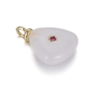 Macro detail of heart-shaped natural stone pendant with pink zircon and gold plating