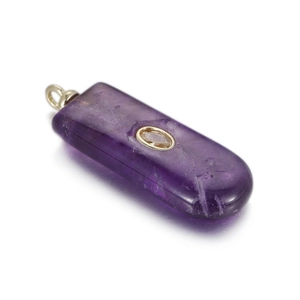 Macro shot of purple natural stone pendant with gold bezel and inset zircon gemstone