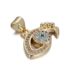 Macro shot of 14k gold Evil Eye pendant featuring white zircon and blue crystal inlays