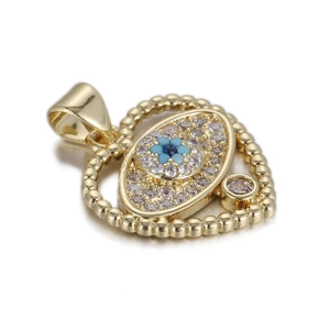 Macro detail of a gold heart pendant with evil eye motif and clear cubic zirconia stones