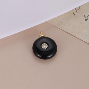 Elegant round black stone pendant with center cubic zirconia and gold plating detail
