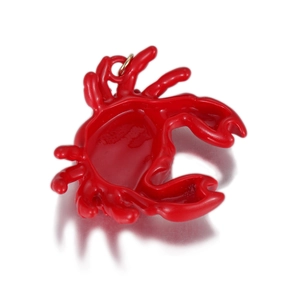 Détail d'un pendentif crabe rouge vif avec anneau doré et finition émaillée polie