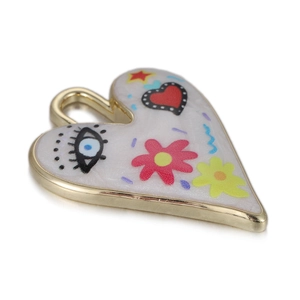 Détail macro d'un pendentif cœur doré avec motifs colorés en émail et œil protecteur