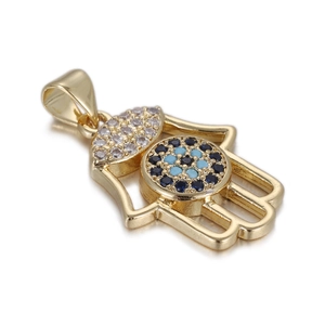 Macro shot of gold Hamsa hand pendant featuring devil eye detail and crystals