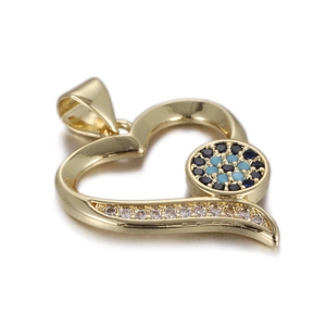 Macro detail of gold-plated heart pendant with evil eye motif and white cubic zirconia