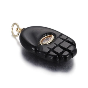 Detailed view of a black palm pendant with golden metal eye inlay and grid patterns