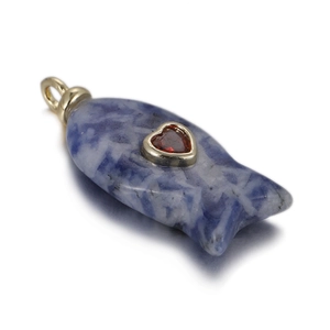 Detail of blue marble fish pendant with a red heart gemstone and golden metal trim