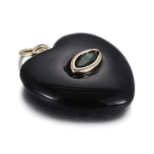 Macro shot of heart-shaped black gemstone pendant with green marquise stone inlay