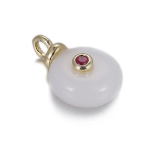 Macro shot of circular white jade pendant with a central red gemstone and gold bezel setting