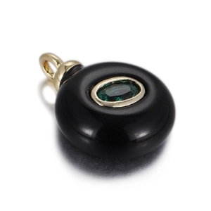 Detail of round black agate pendant with faceted green emerald center in gold bezel