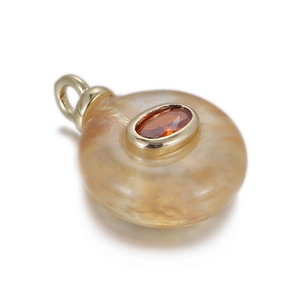 Detailed macro view of an orange jade pendant with a central orange zircon and gold clasp