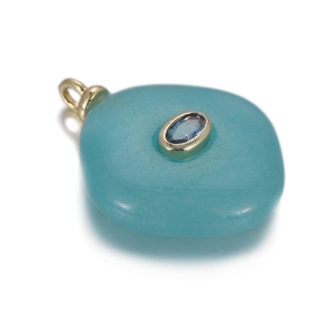 Detailed view of pebble-shaped green gemstone pendant with blue inlay and gold trim