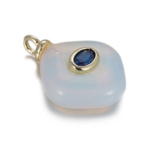 Close-up of translucent white gemstone pendant with blue inlay and gold ring