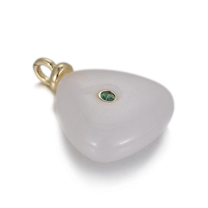 Close-up of heart-shaped white jade pendant with small green gemstone inlay and gold loop