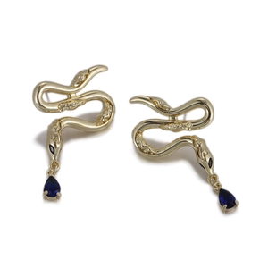 Vue détaillée de boucles d'oreilles serpent dorées avec pendentifs en zircon bleu foncé