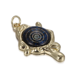 Macro-opname van een gouden hanger met een blauwe inleg en fijne reliëfstructuren