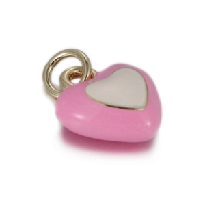 Détail macro d'une breloque cœur en émail rose et blanc avec anneau doré pour bijoux