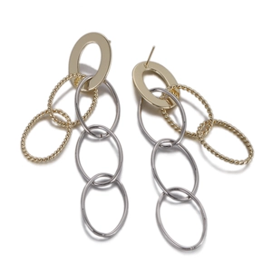 Détail de boucles d'oreilles entrelacées bicolores or et argent avec finition texturée