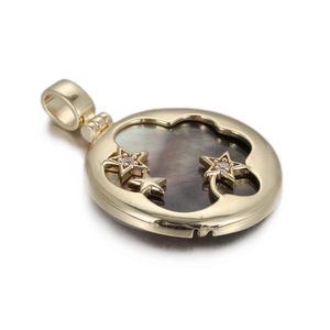 Detail of round gold pendant with cloud cutout, black shell inlay, and tiny gold stars