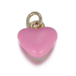 Macro d'un pendentif cœur rose avec anneaux dorés pour la création de bijoux DIY