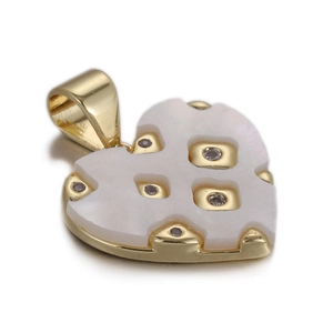 Detail of heart pendant with white inlay and gold metal accents with cubic zirconia